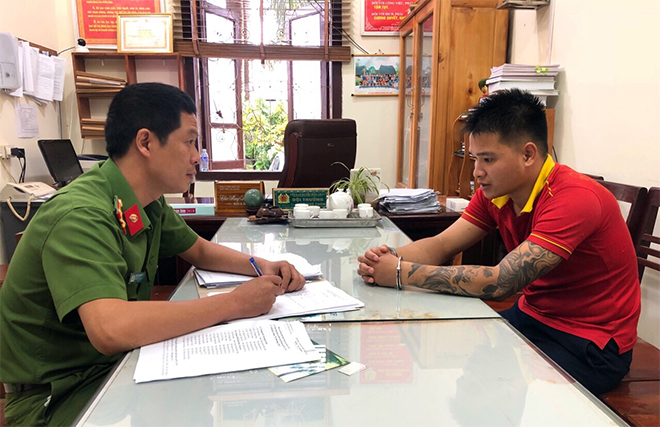 Trung tá Vũ Quang Hưng lấy lời khai của đối tượng.