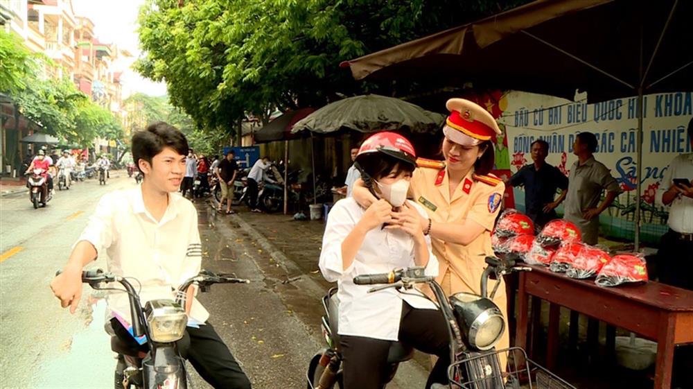 CSGT Công an tỉnh Bắc Ninh đảm bảo trật tự, an toàn giao thông và phát mũ bảo hiểm tặng các thí sinh và phụ huynh. 