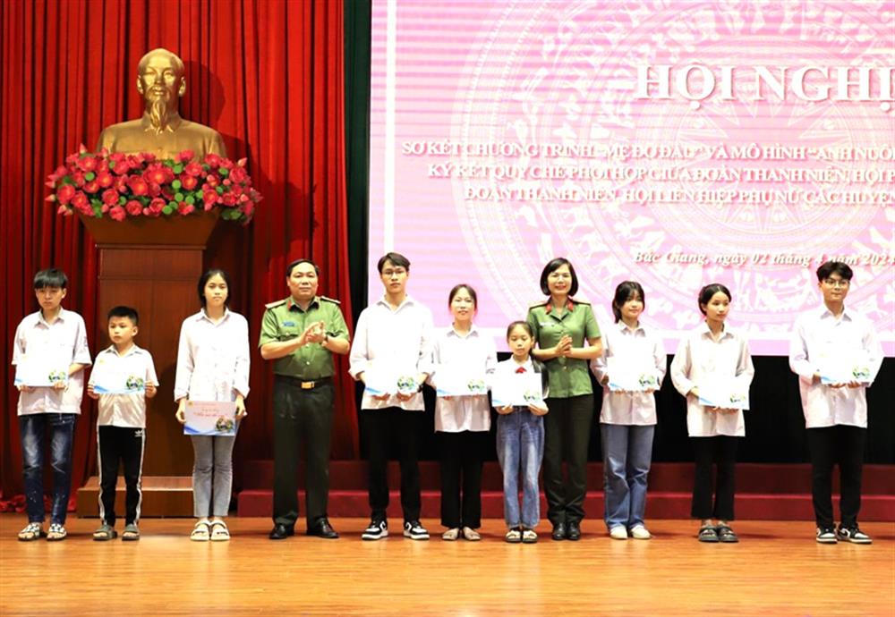 Đại tá Trần Thế Cường, Phó Giám đốc Công an tỉnh và Thượng tá Nguyễn Thị Quế, Phó trưởng Ban Phụ nữ Công an nhân dân trao học bổng tặng các em học sinh.