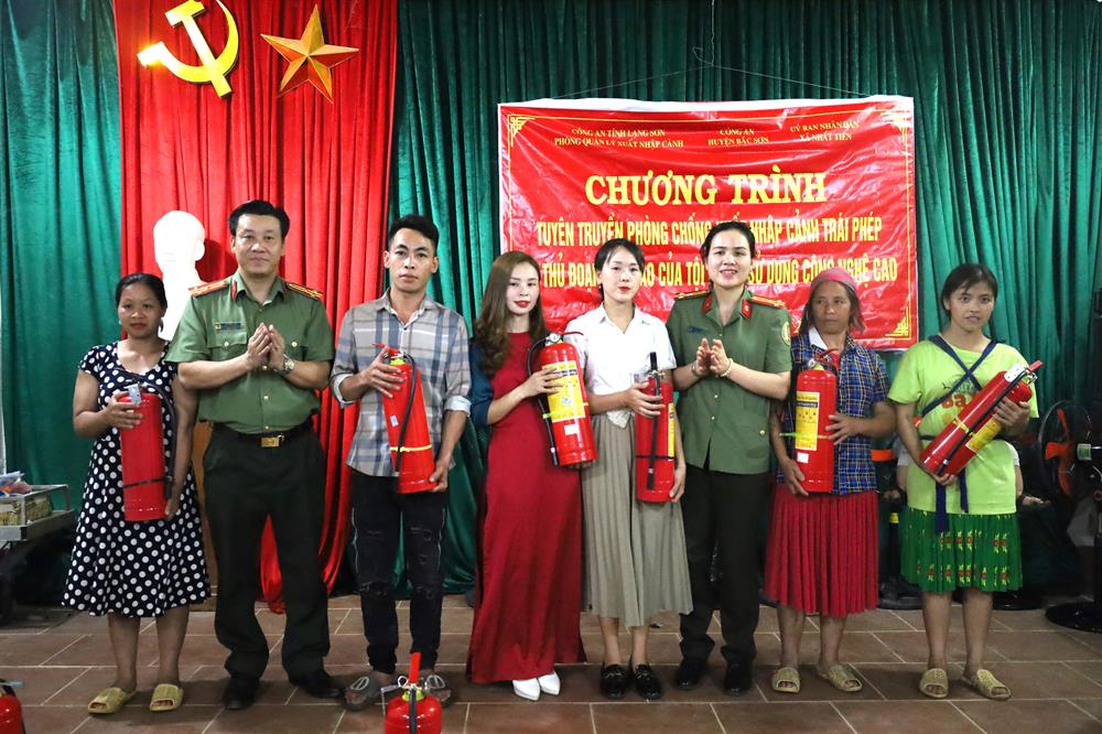 Lãnh đạo Phòng Quản lý xuất nhập cảnh và Công an huyện Bắc Sơn trao bình chữa cháy cho nhân dân Thôn Tiến Hậu.