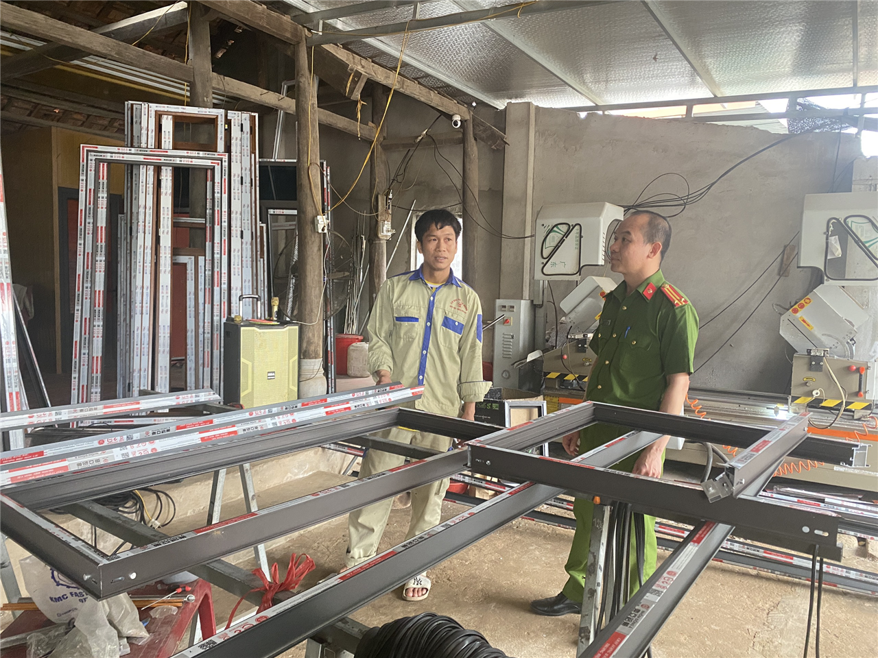 Anh Trung giới thiệu về công việc tại nhà xưởng cho cán bộ Công an huyện.
