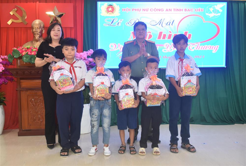 Đại tá Trương Công Dũng, Phó Giám đốc Công an tỉnh và đại diện Hội Liên hiệp Phụ nữ tỉnh tặng quà các cháu mồ côi đang được nhận đỡ đầu.