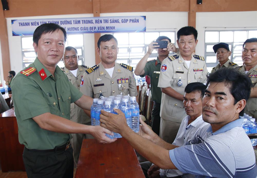 Lãnh đạo Phòng Hậu cần Công an tỉnh An Giang trao nước uống tặng người dân.