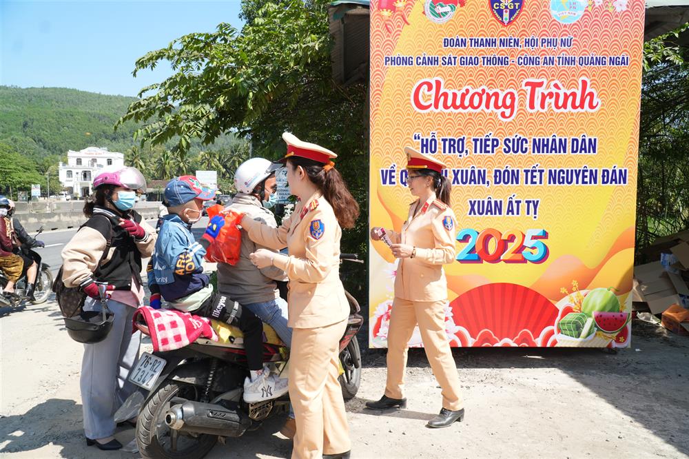 Lực lượng CSGT hỗ trợ những người về quê bằng xe máy trong chiều ngày 28/1.
