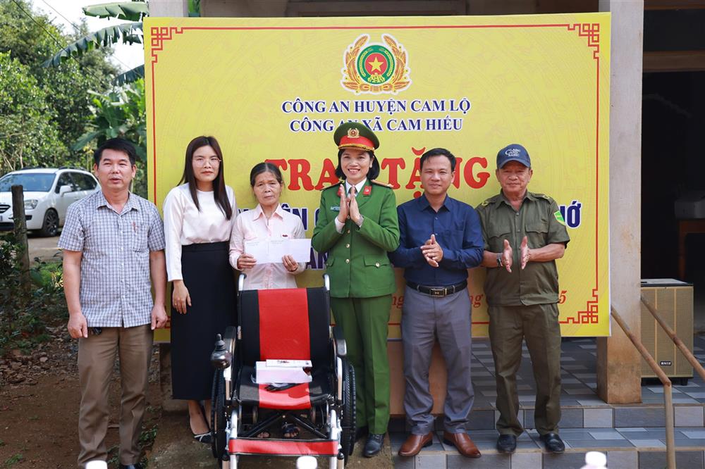 Thân nhân gia đình em Lê Thị Hoài Nhớ nhận quà tặng từ Công an xã Cam Hiếu và các nhà hảo tâm.