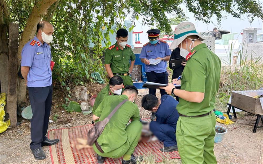 Lực lượng chức năng khai quật và khám nghiệm tử thi.