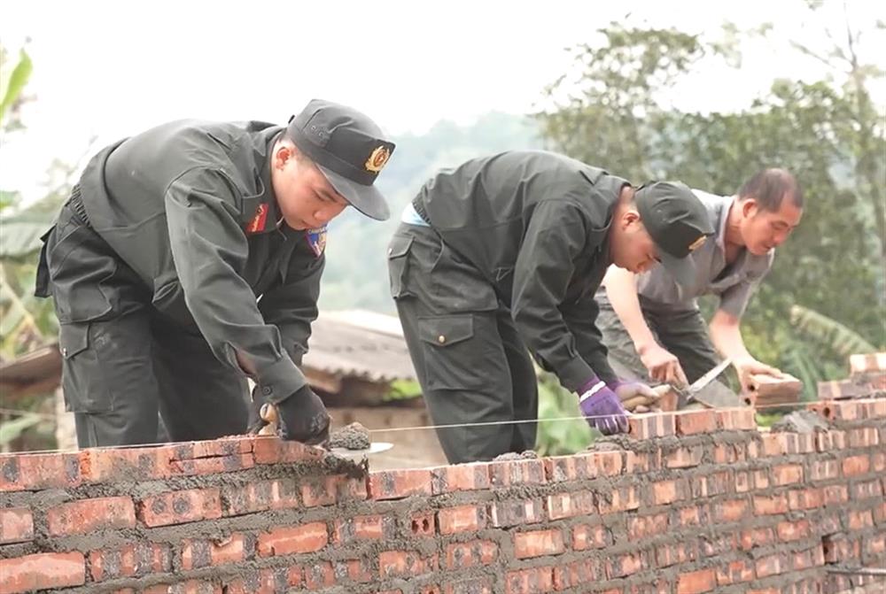 Cán bộ, chiến sỹ vận chuyển vật liệu và tiến hành xây dựng nhà mới cho các hộ dân.