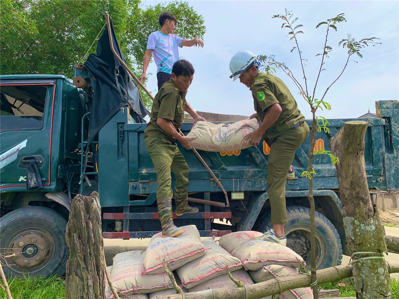 Lực lượng an ninh tại cơ sở hỗ trợ vận chuyển vật tư xây dựng.