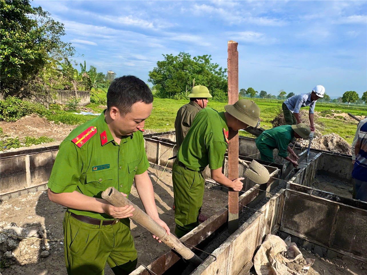 Lực lượng Công an xã hỗ trợ thi công xây dựng nhà ở cho hộ nghèo.
