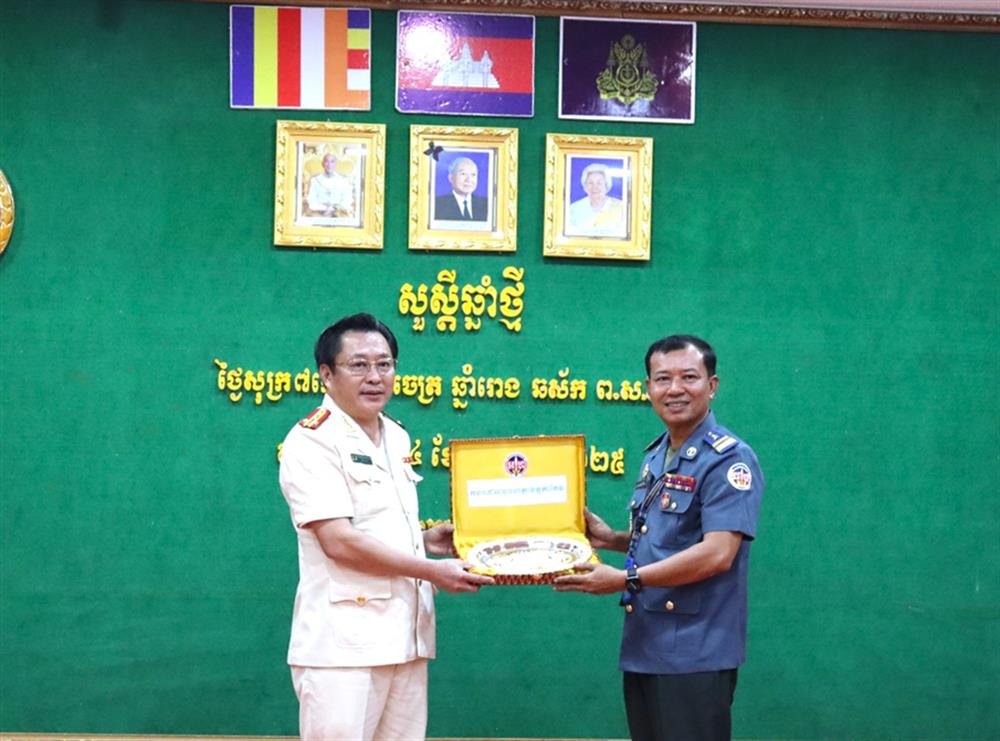 Đại tá Lâm Phước Nguyên, Giám đốc Công an tỉnh An Giang nhận quà lưu niệm từ Trung tá Sok DaRa, quyền Chỉ huy trưởng Bộ Chỉ huy Hiến binh tỉnh Takeo.