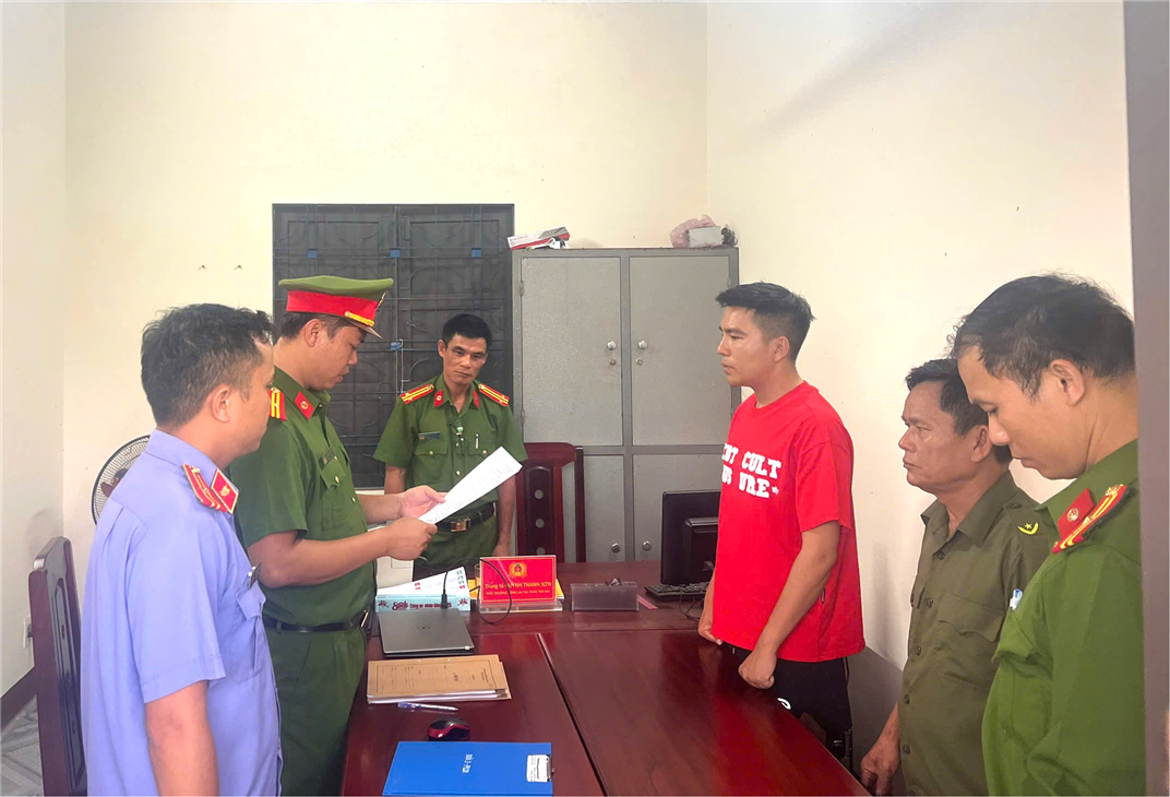 Văn phòng Cơ quan Cảnh sát điều tra Công an tỉnh Quảng Nam tống đạt các quyết định và lệnh đối với Mai Văn Dưỡng (áo đỏ).