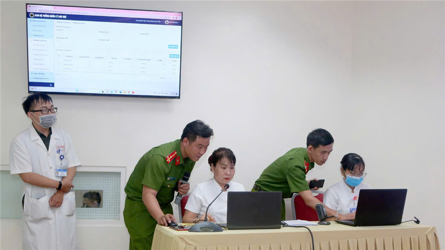 Thượng úy Đinh Viết Lợi (bên trái) tuyên truyền về những quy định, tiện ích của ứng dụng định danh và xác thực điện tử tại Bệnh viện Trung ương Huế.