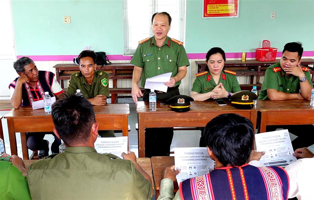 Cán bộ, chiến sĩ Công an tỉnh Bình Định tuyên truyền về tội phạm lừa đảo trên không gian mạng cho Ban quản lý làng Cà Sim, xã Canh Thuận, huyện Vân Canh.