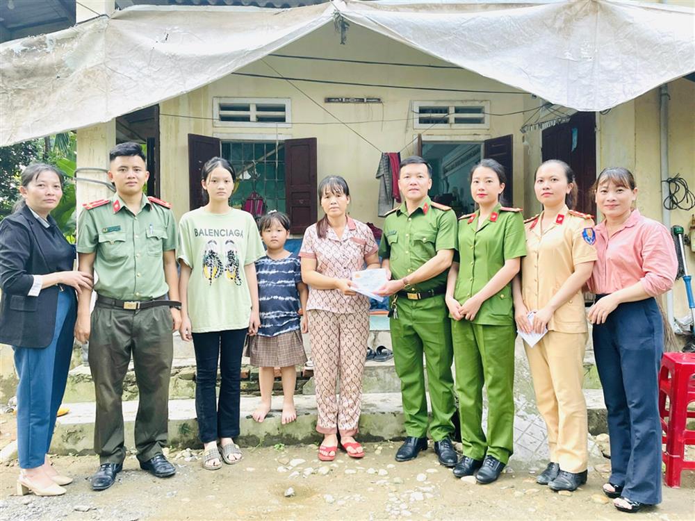 Thượng tá Huỳnh Đức Mẫn (thứ 4 từ bên phải qua) trao quà tặng người dân có hoàn cảnh khó khăn.