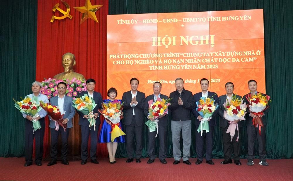 Bộ trưởng Tô Lâm và Bí thư Tỉnh ủy Nguyễn Hữu Nghĩa tặng hoa các nhà tài trợ.