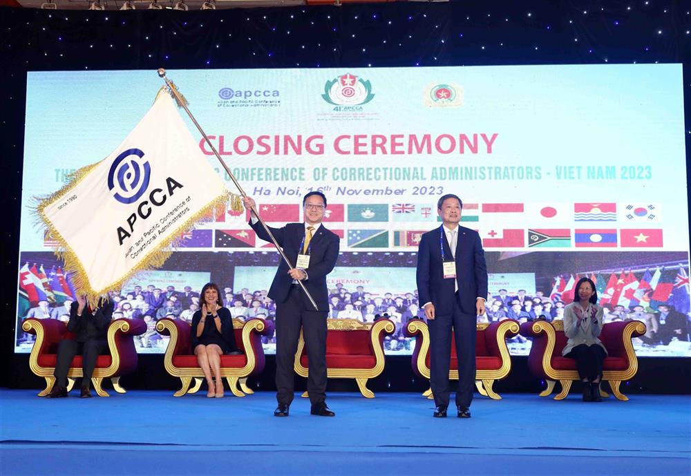 Trung tướng Lê Minh Hùng, Chủ tịch APCCA 41 trao cờ cho ông Wang Kwok-Hing, Trưởng đoàn đại biểu Hong Kong (Trung Quốc) - chủ nhà Hội nghị APCCA 42.