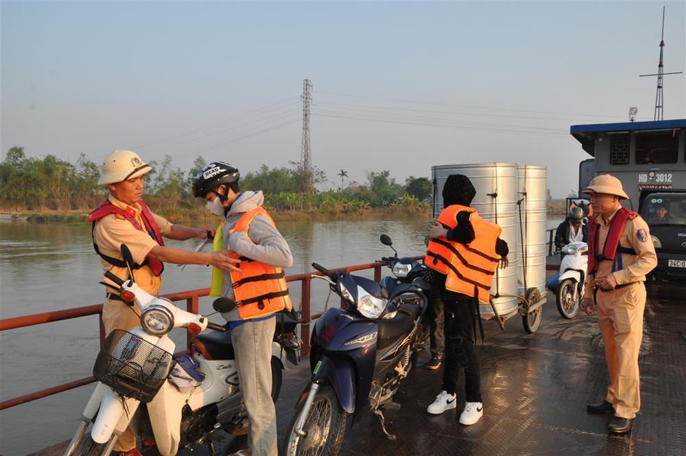 Lực lượng CSGT đường thủy tuyên truyền, phát tờ rơi, hướng dẫn học sinh và khách qua sông mặc áo phao cứu sinh khi lên đò phà di chuyển qua sông.