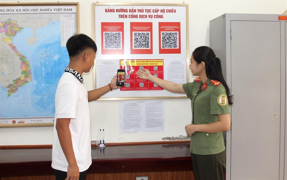 - Cán bộ phòng Quản lý xuất nhập cảnh Công an Hà Nam tuyên truyền, hướng dẫn người dân thực hiện quét mã QR code làm thủ tục xuất nhập cảnh.