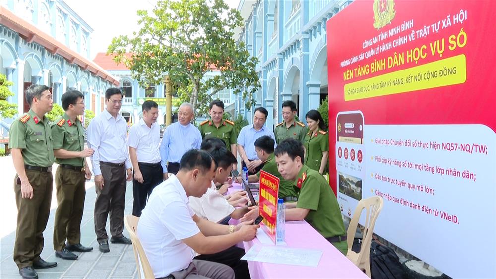 Các đại biểu tham quan điểm hướng dẫn người dân kích hoạt, đăng nhập, sử dụng VNeID và tham gia phong trào “Bình dân học vụ số”.