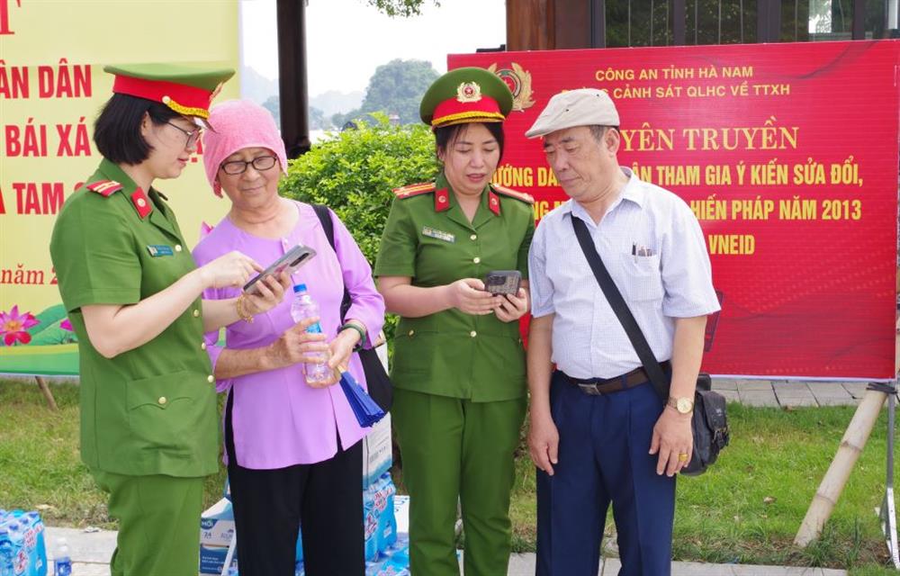 Cán bộ, chiến sĩ các tổ công tác tuyên truyền, hướng dẫn người dân, Phật tử và du khách tham gia góp ý vào dự thảo sửa đổi Hiến pháp năm 2013 trên ứng dụng VNeID tại Khu du lịch Tam Chúc.