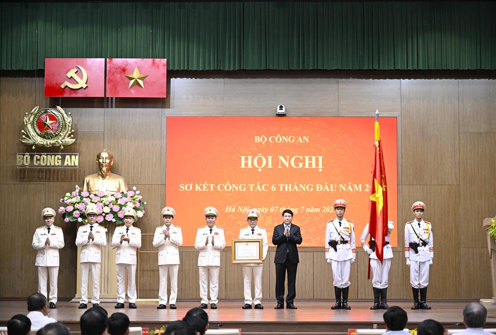 Chủ tịch nước Lương Cường gắn Huân chương lên lá Cờ truyền thống và trao Bằng Huân chương Lao động hạng Ba tặng Bộ Công an.