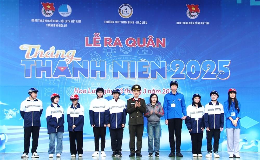 Thiếu tá Lã Hữu Hưng, Trưởng Ban Thanh niên Công an tỉnh và đại diện Công ty Honda Thanh Hải tặng mũ bảo hiểm cho các em học sinh.