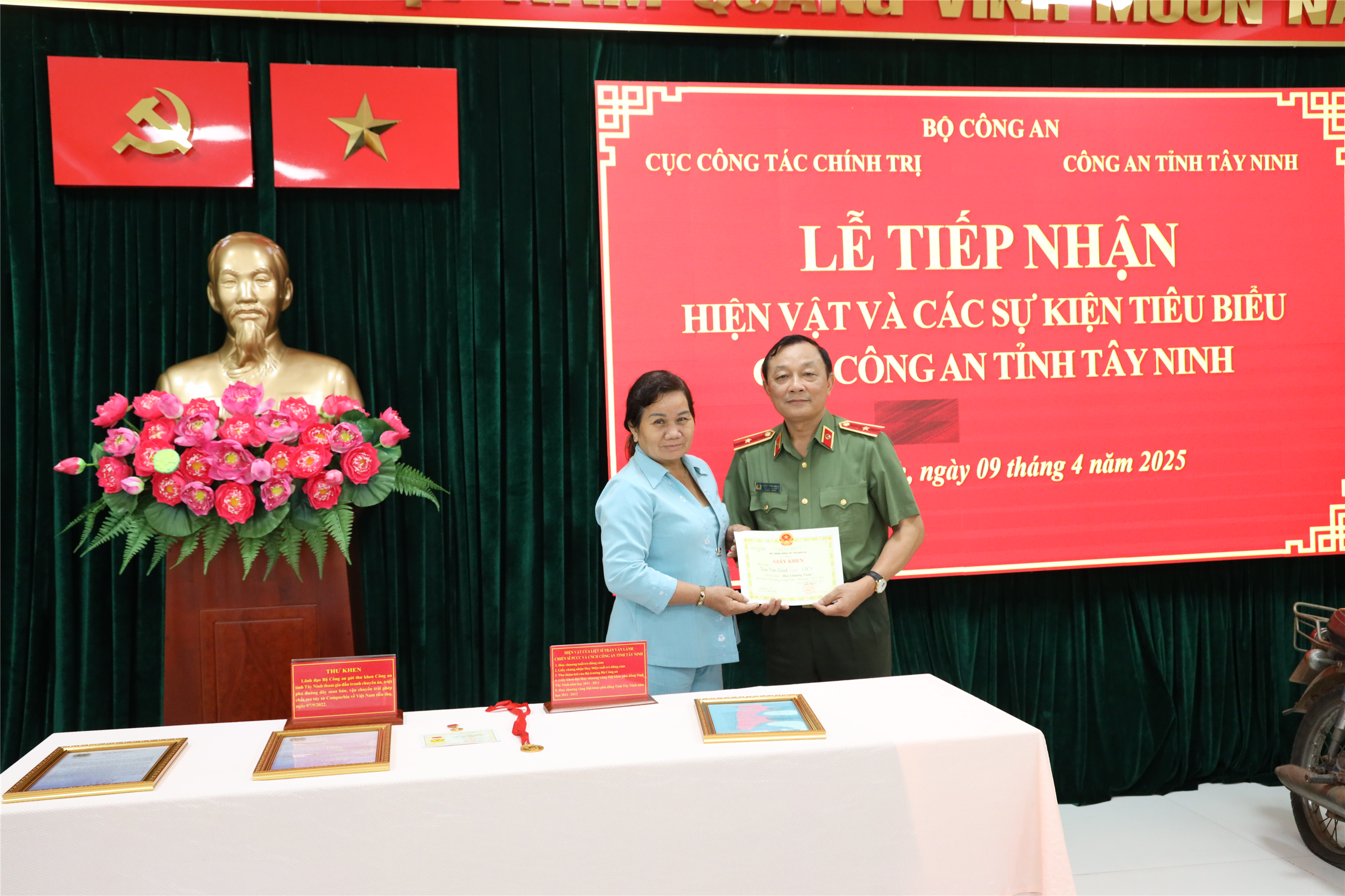 Thiếu tướng Đặng Ngọc Bách, Phó Cục trưởng Cục Công tác chính trị tiếp nhận hiện vật từ mẹ của liệt sĩ Trần Văn Lành.