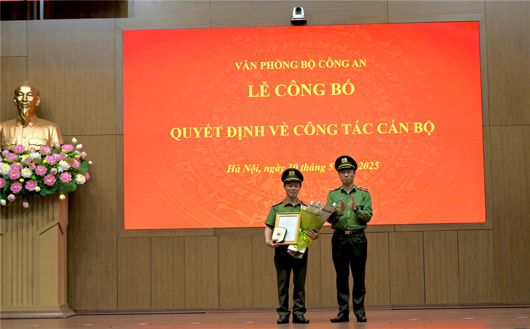 Đồng chí Thiếu tướng Nguyễn Quốc Toản, Chánh Văn phòng Bộ tặng hoa và trao quyết định cho đồng chí Thượng tá Hoàng Nguyên Ngọc.
